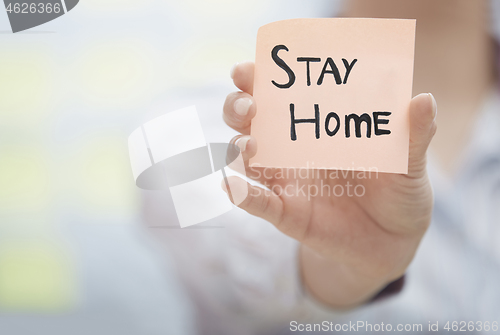 Image of Hands holding sticky note with Stay Home text