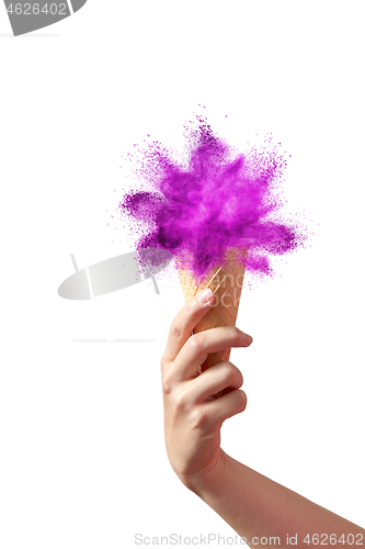 Image of Crispy waffle cone with ice cream as an abstract splash in woman\'s hand.