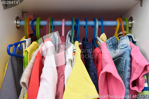 Image of Baby things are hanging in the closet on hangers