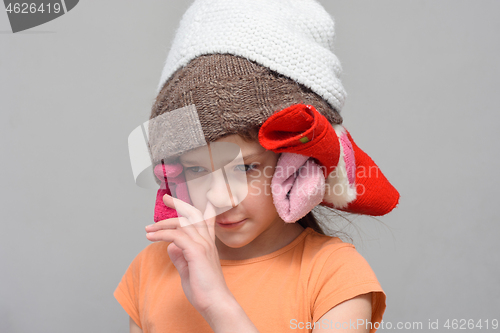 Image of Girl picking her nose with a homemade funny hat