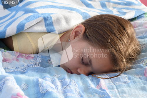 Image of Tired girl fell asleep in the afternoon on the bed