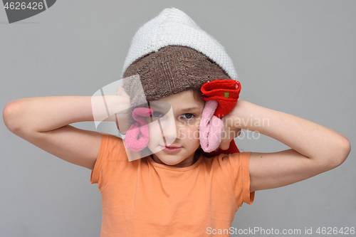 Image of The girl put on a lot of things on her head so as not to hear loud sounds