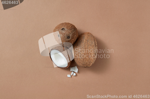 Image of Three fresh natural organic coconut fruits on a brown background.