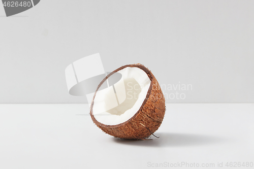 Image of Half of fresh ripe tropical coconut fruits on light grey background.