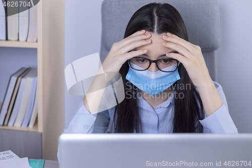 Image of Exhausted businesswoman working during the coronavirus pandemic