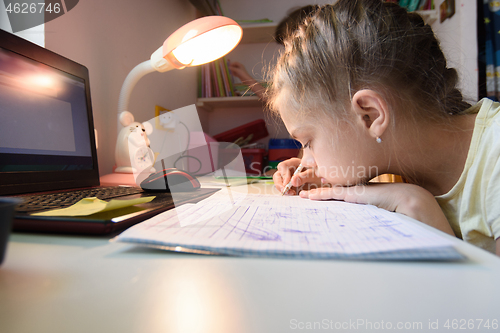 Image of The girl is studying at home remotely while in her room