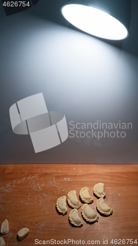 Image of Uncooked dumplings on the kitchen board lighting the lamp lanter