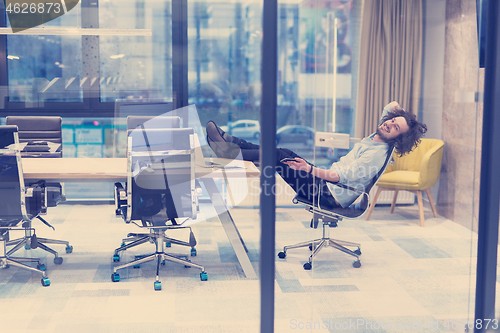 Image of young businessman relaxing at the desk