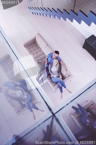 Image of youg couple in living room with tablet top view