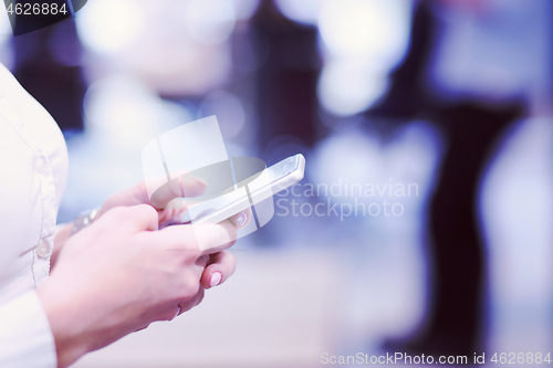 Image of Elegant Woman Using Mobile Phone in startup office building