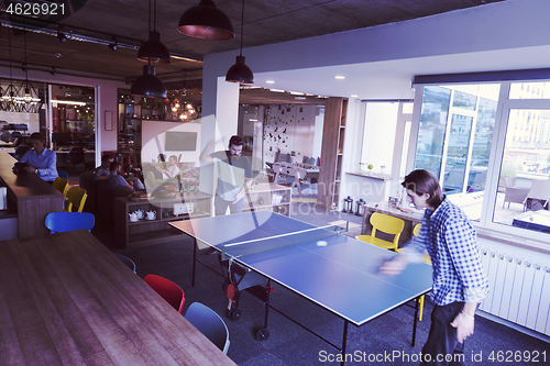 Image of playing ping pong tennis at creative office space