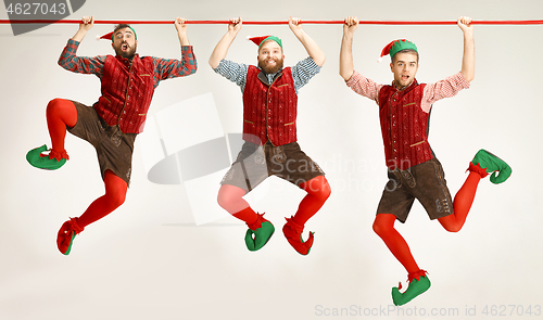 Image of friendly men dressed like a funny gnome posing on an isolated gray background