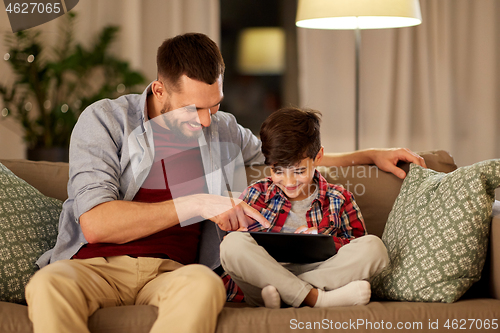 Image of father and son with tablet pc playing at home