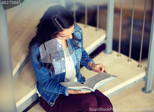 Image of high school student girl reading book on stairs