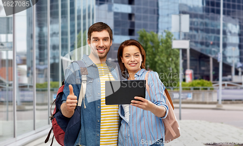 Image of couple of tourists with tablet computer in city