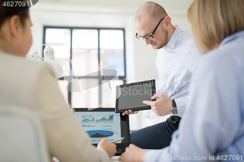 Image of close up of business team with tablet pc at office