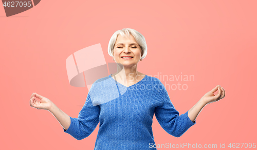 Image of smiling senior woman in blue sweater chilling