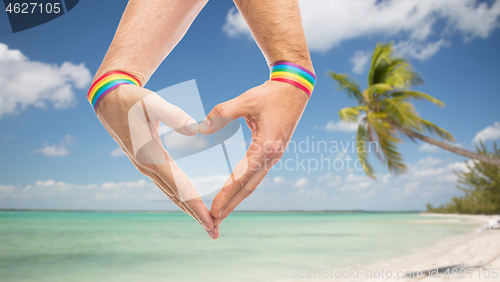 Image of male hands with gay pride wristbands showing heart