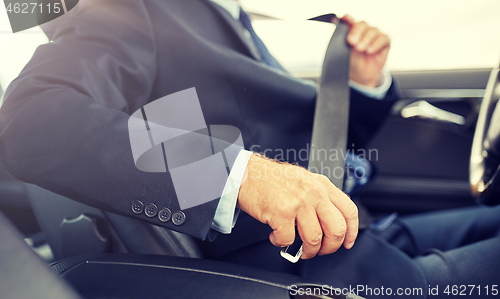 Image of senior businessman fastening car seat belt