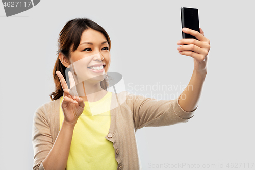 Image of asian woman taking selfie by smartphone