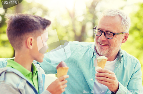 Image of old man and boy eating ice cream at summer park