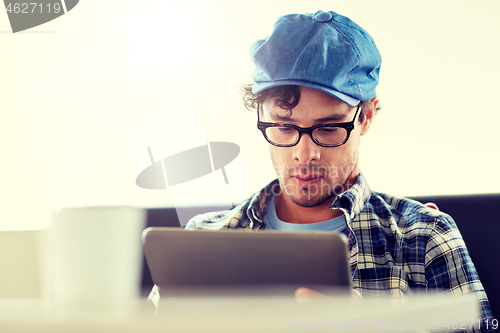 Image of man with tablet pc sitting at cafe table