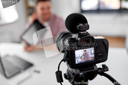 Image of camera recording video blogger with tablet pc