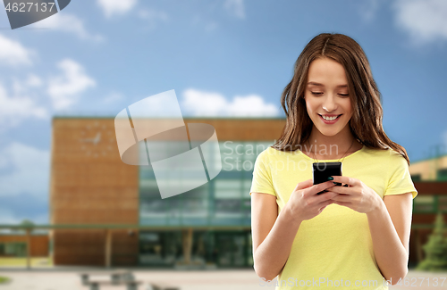 Image of teenage girl using smartphone over school