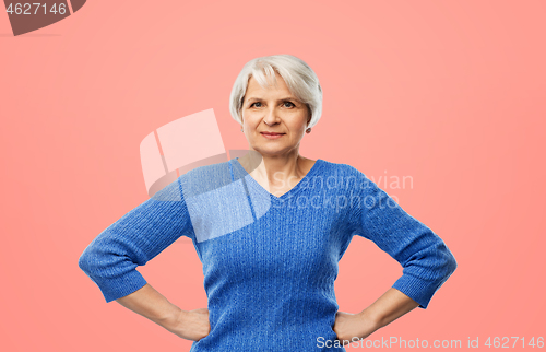 Image of senior woman in blue sweater hands on hips