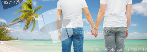 Image of male couple with gay pride rainbow wristbands