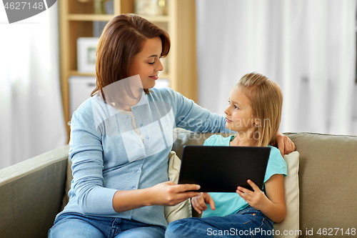 Image of happy mother and daughter with tablet pc at home