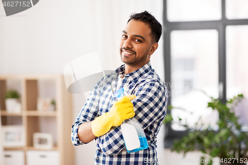 Image of smiling indian man with detergent cleaning at home