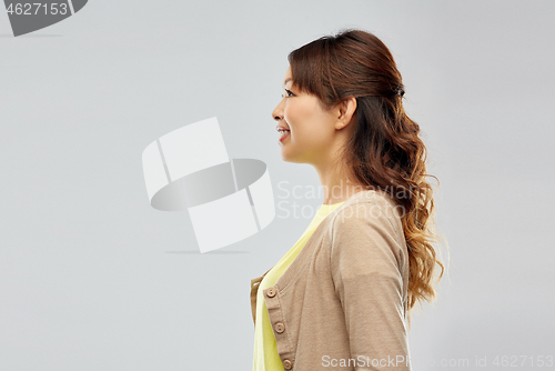 Image of happy asian woman over grey background