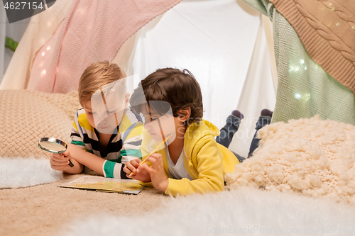 Image of boys with magnifier and map in kids tent at home