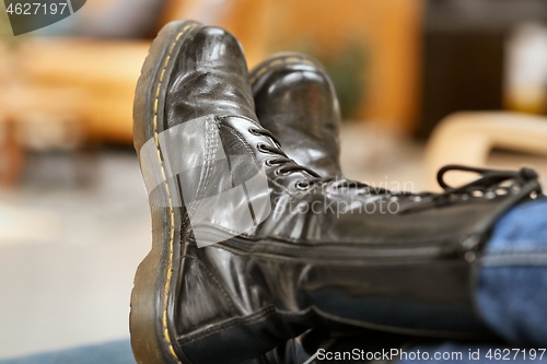 Image of Leather boots legs up on a chair