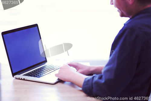 Image of businessman working using a laptop in startup office