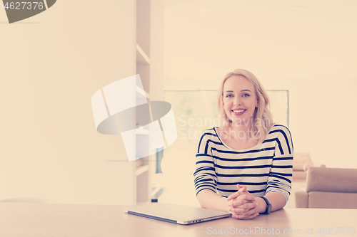 Image of Young woman with laptop at home