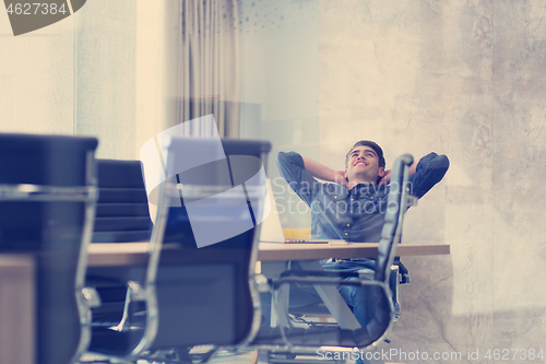 Image of young businessman relaxing at the desk