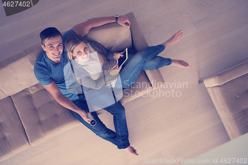 Image of youg couple in living room with tablet top view