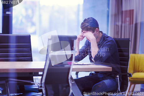 Image of young businessman relaxing at the desk