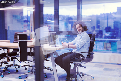 Image of Young casual businessman using smartphone