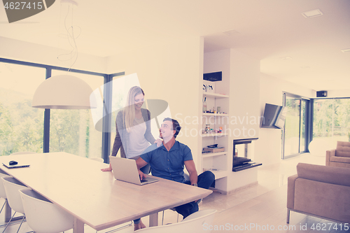 Image of couple using laptop at home