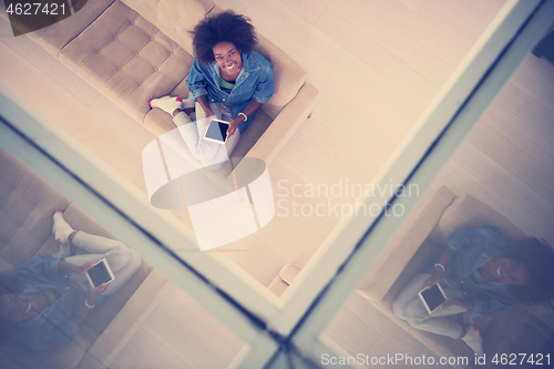 Image of african american woman at home with digital tablet top view