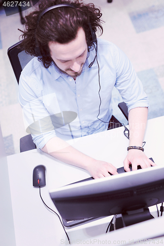 Image of male call centre operator doing his job top view