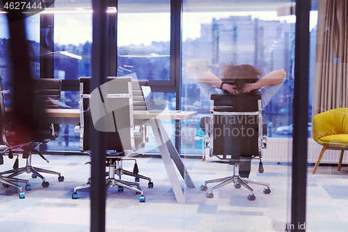 Image of young businessman relaxing at the desk