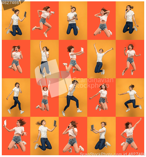 Image of Freedom in moving. Pretty young woman jumping against orange background