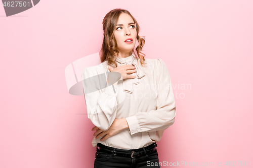 Image of Let me think. Doubtful pensive woman with thoughtful expression making choice against pink background