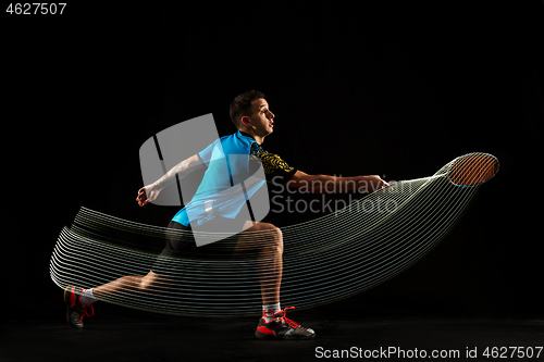 Image of Young male badminton player over balck background