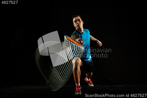 Image of Young male badminton player over balck background