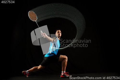 Image of Young male badminton player over balck background